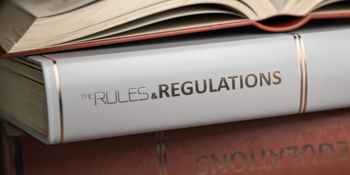 A stack of books titled "Rules and Regulations" and an SEC enforcement manual rests on a table in a law firm.